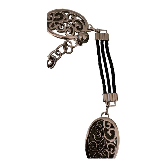 Belt, silver oval medallions connected with black leather cords.